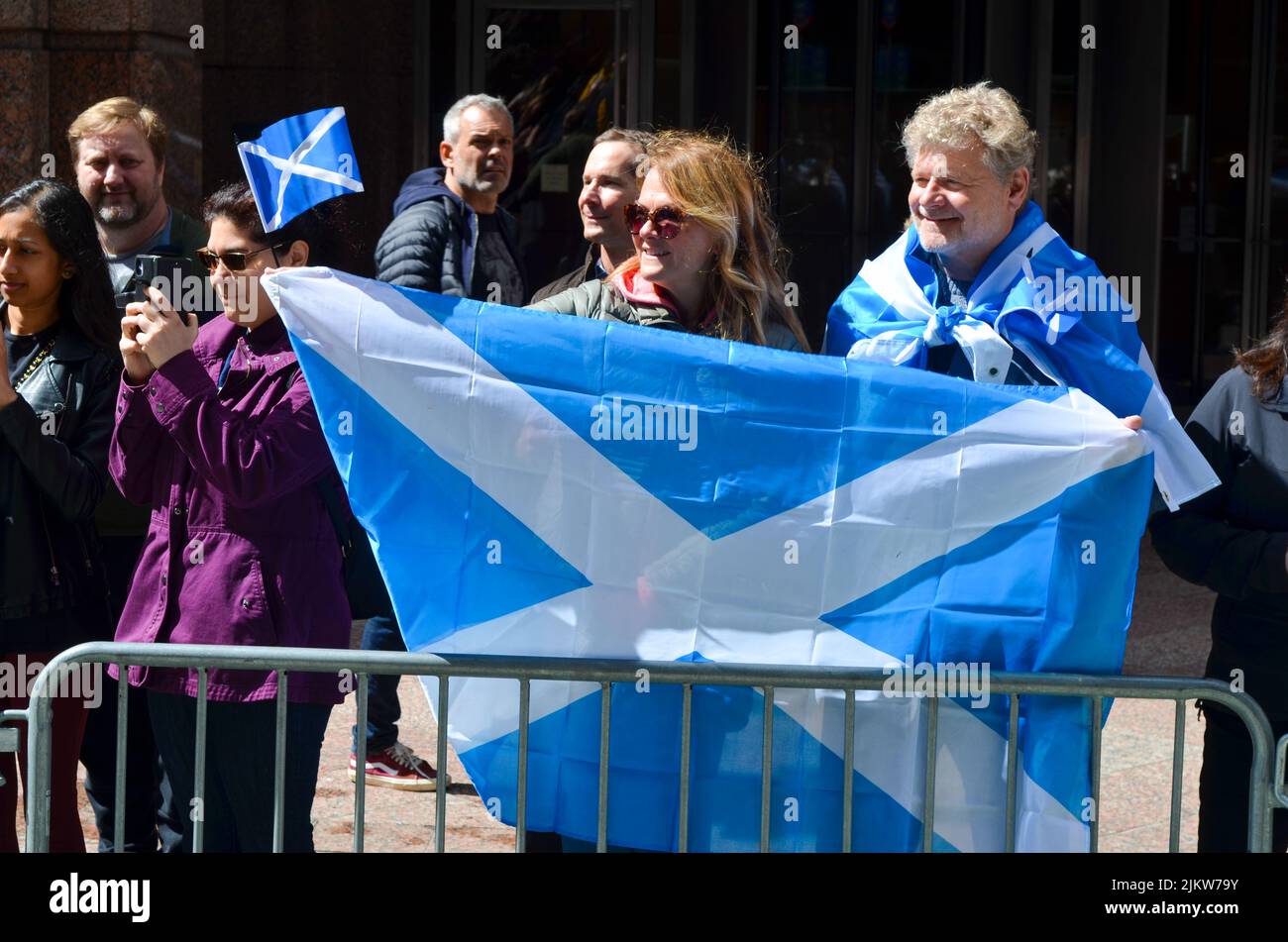 Spectators wearing scottish flag during the world's largest pipe and drum parade to celebrate Scottish Tartan Day on April 9, 2022 in New York City. Stock Photo