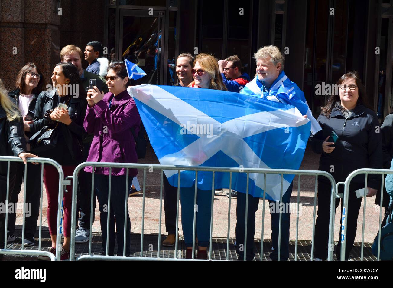 Spectators wearing scottish flag during the world's largest pipe and drum parade to celebrate Scottish Tartan Day on April 9, 2022 in New York City. Stock Photo