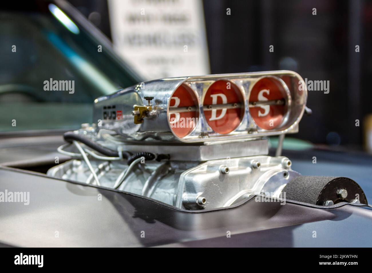 Supercharger sticking out of a hood of a car with butterfly valves