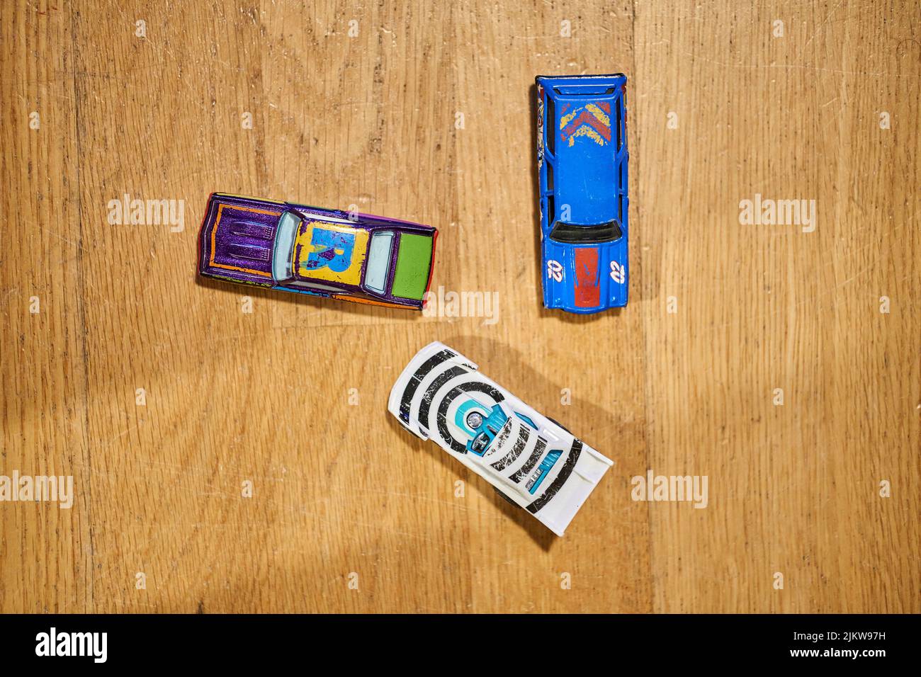 A top view of Mattel Hot Wheels brand toy model cars on a wooden surface Stock Photo