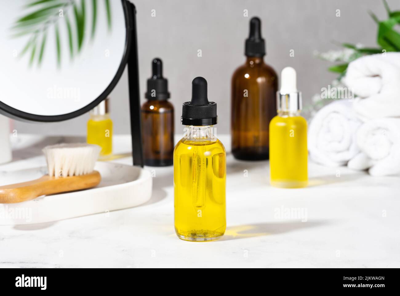 Oils, bath brush, towel and mirror on the cosmetic table in the