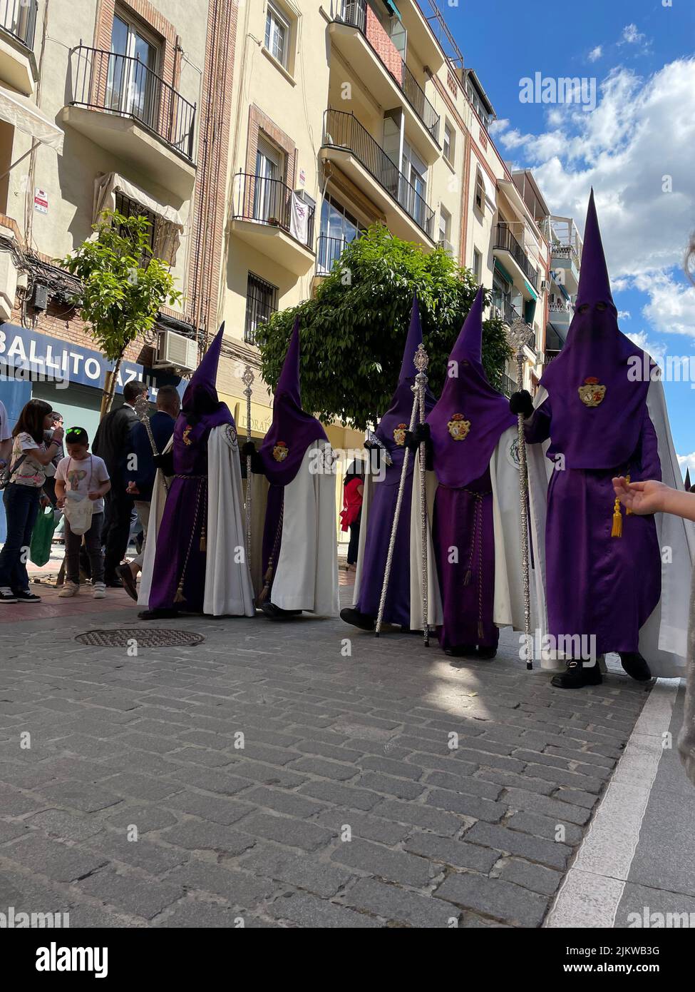 A vertical shot of The Brotherhood of the Cigarreras on its route along Asuncion Street in Seville, Spain Stock Photo