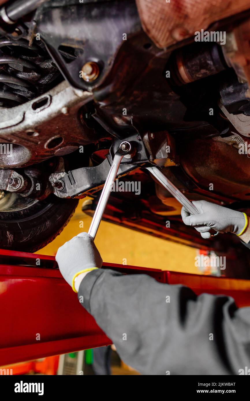 Car mechanic installing wheel alignment sensors, car suspension adjustment. Car mechanic at work