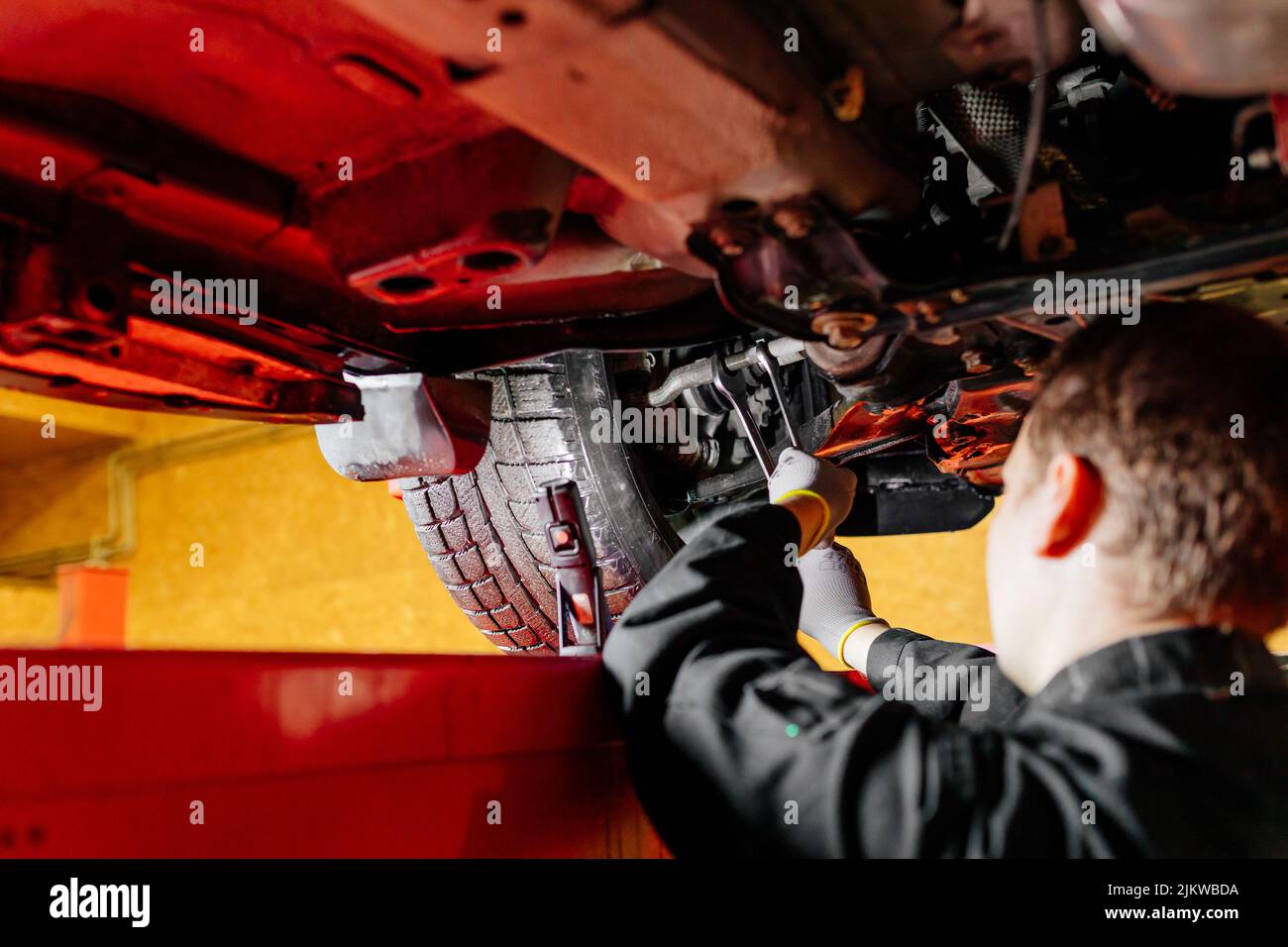 Car mechanic installing wheel alignment sensors, car suspension adjustment. Car mechanic at work