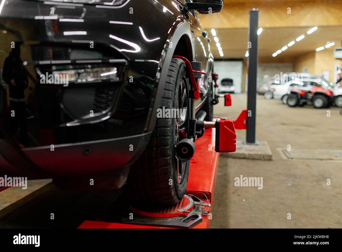 Car mechanic installing wheel alignment sensors, car suspension
