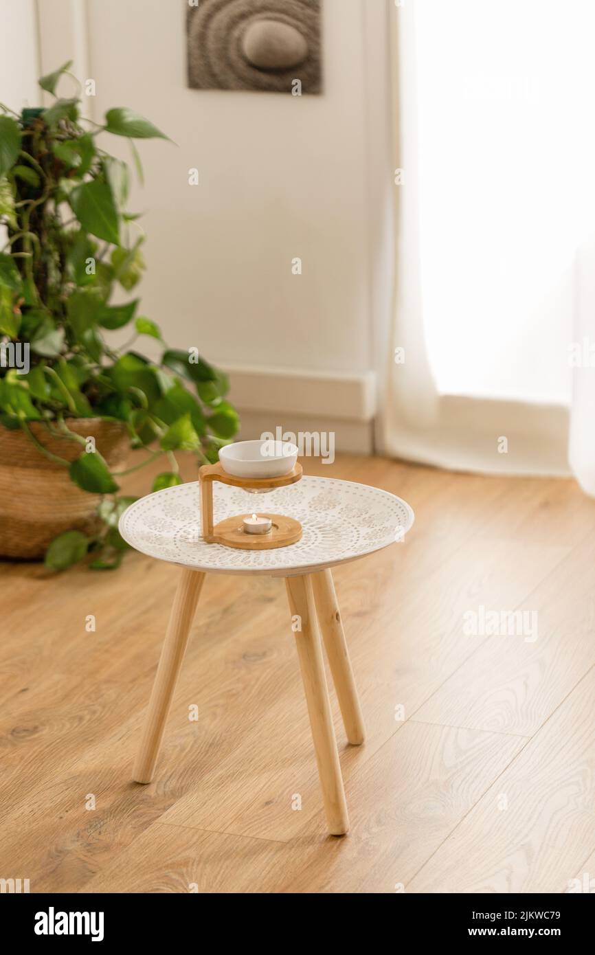 A vertical top view of essential oils for massage in a bowl on a wooden stand on a small table Stock Photo