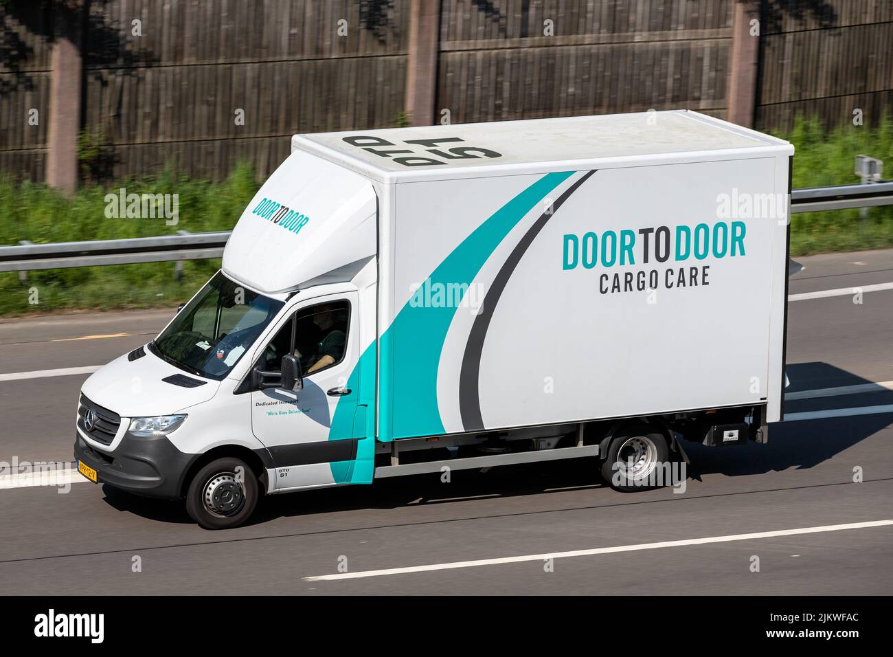 Door to Door Cargo Care Mercedes-Benz Sprinter van on motorway Stock Photo