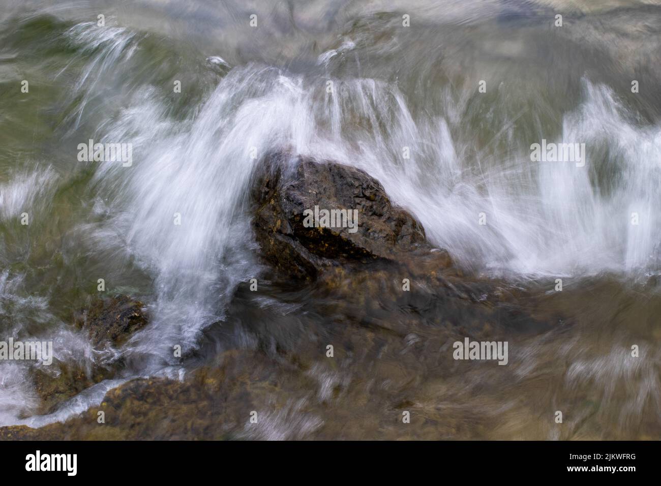 A closeup of a wave hitting the stone Stock Photo
