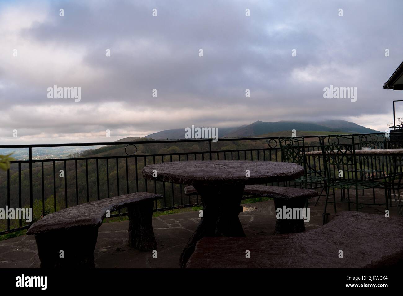 A viewpoint destination with a table and benches looking out to a mountainous view in the distance Stock Photo
