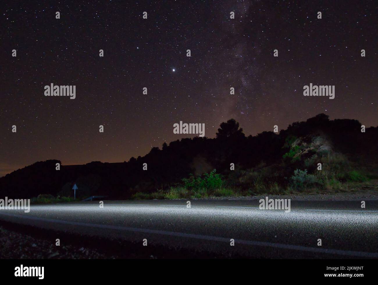 A road and silhouette of trees under a starry night sky Stock Photo - Alamy