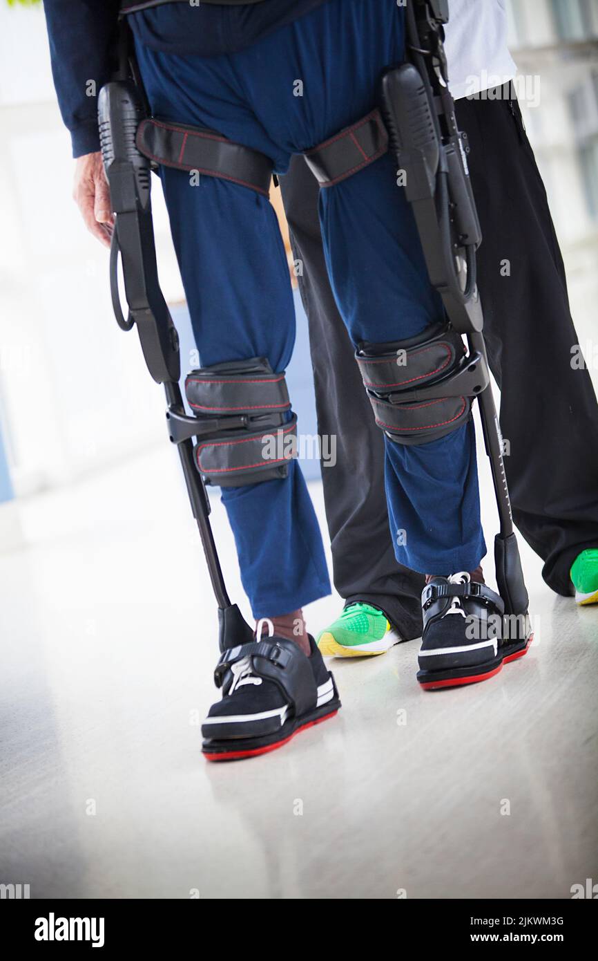 Post-stroke neurological rehabilitation of a patient with paralysis of both legs using a bionic exoskeleton. Stock Photo