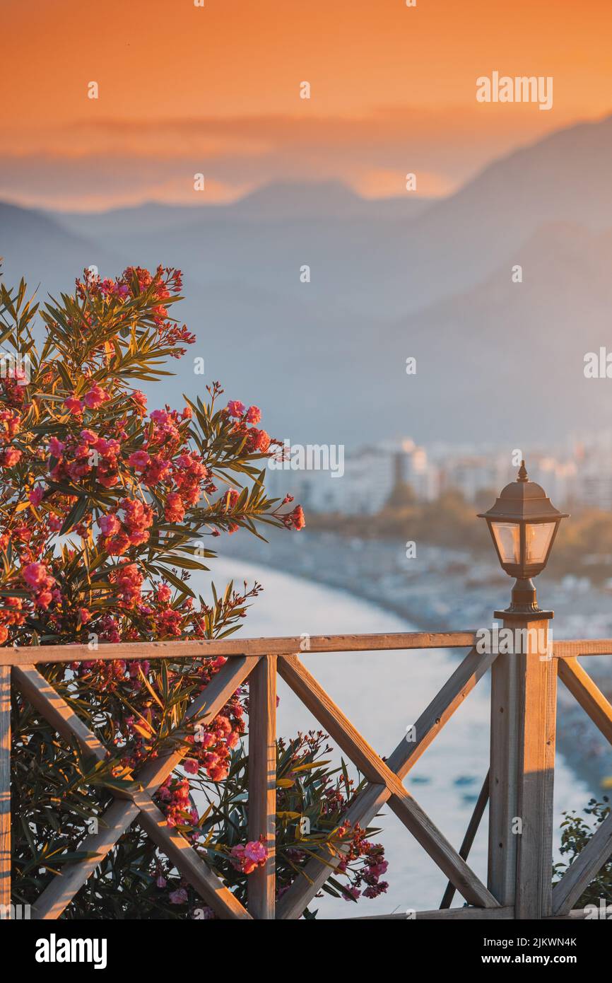 Famous Konyaalti beach, scenic cityscape view from a view point. Decorative lantern and wooden fence and blooming flowers in spring time. Travel desti Stock Photo