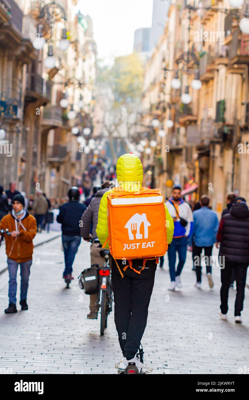 Barcelona, Spain - April 4, 2022: fast food delivery ( just eat) with scooter in the gothic quarter of Barcelona (Spain), selective approach- Stock Photo