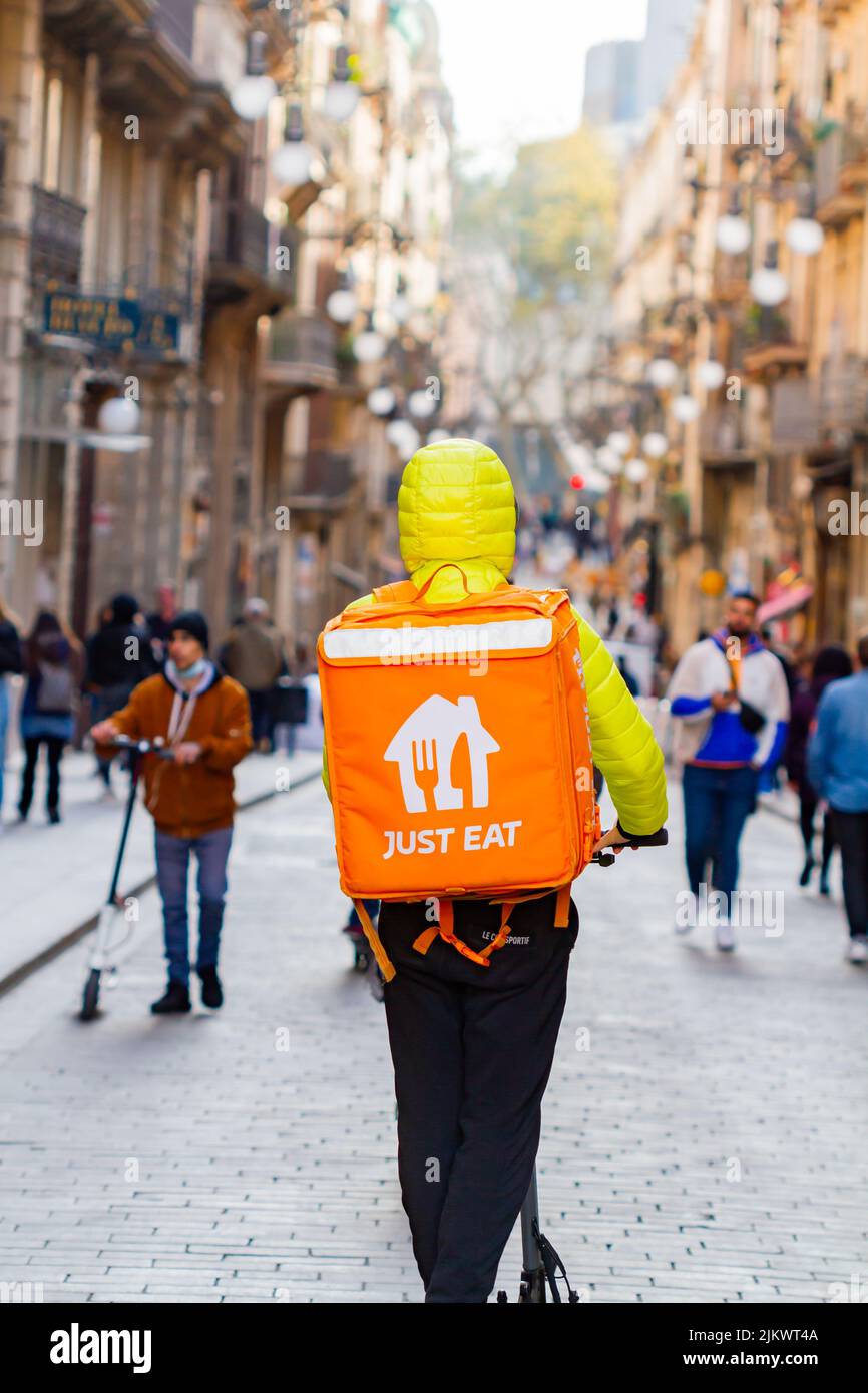 Barcelona, Spain - April 4, 2022: fast food delivery ( just eat) with scooter in the gothic quarter of Barcelona (Spain), selective approach- Stock Photo