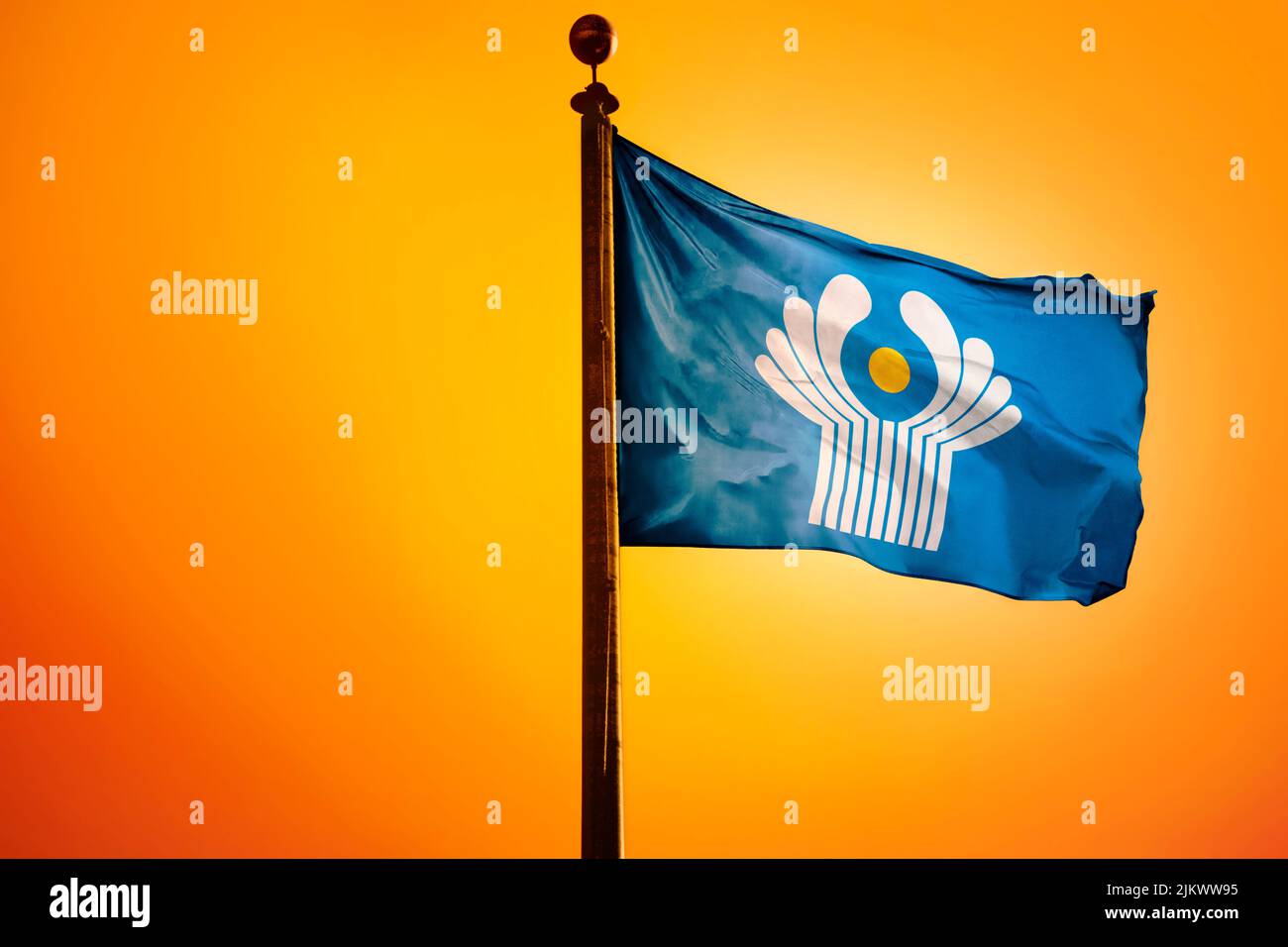 A digital illustration of the flag of the Commonwealth of Independent States waving against a bright yellow sky Stock Photo