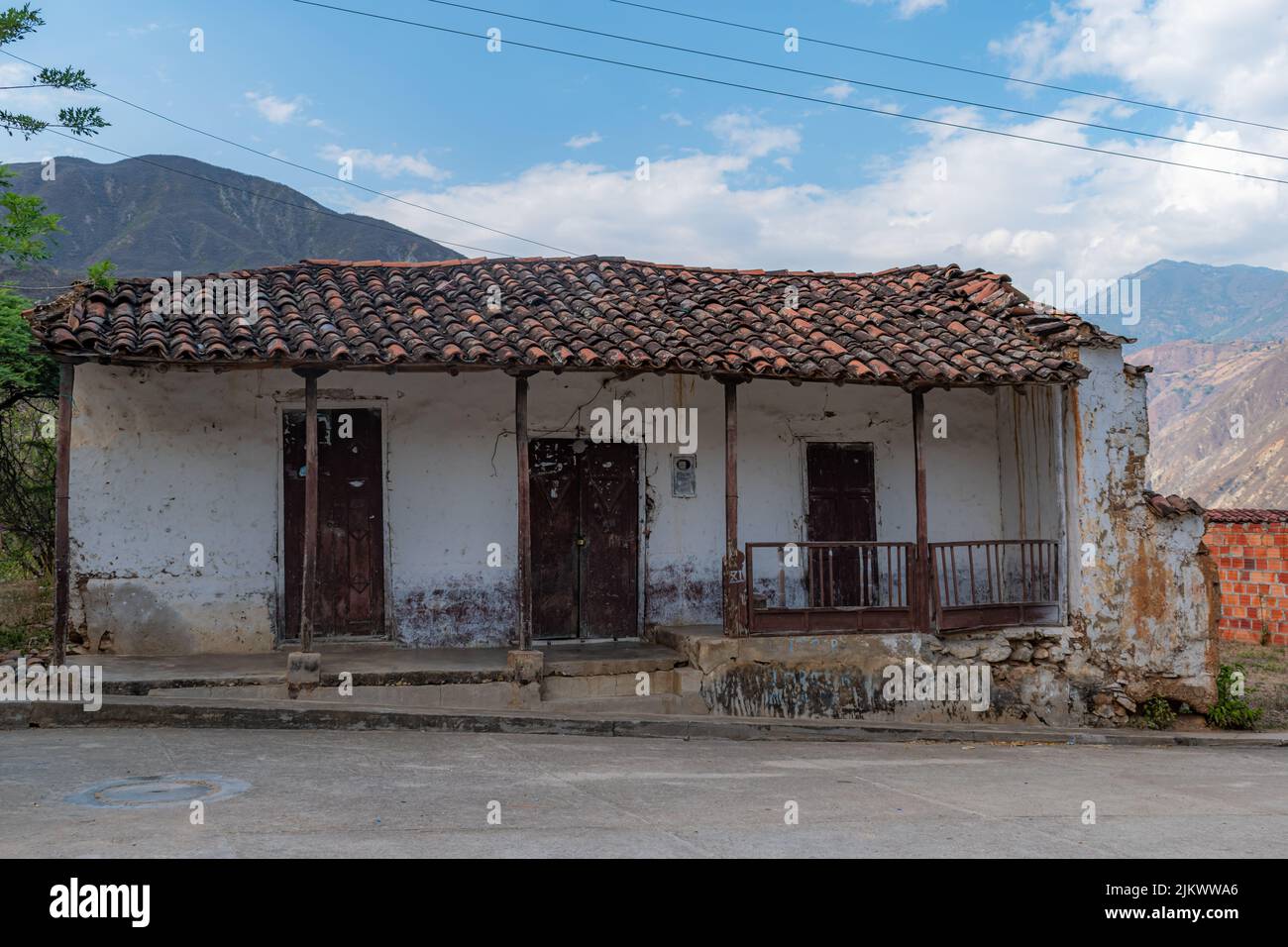 An old stone building with a weathered tiled roof. The landscapes are from the Chicamocha canyon in the region of Santander-Colombia Stock Photo