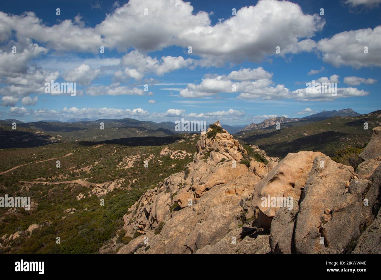 The cloudy blue sky over the green rocky landscapes in spring Stock Photo