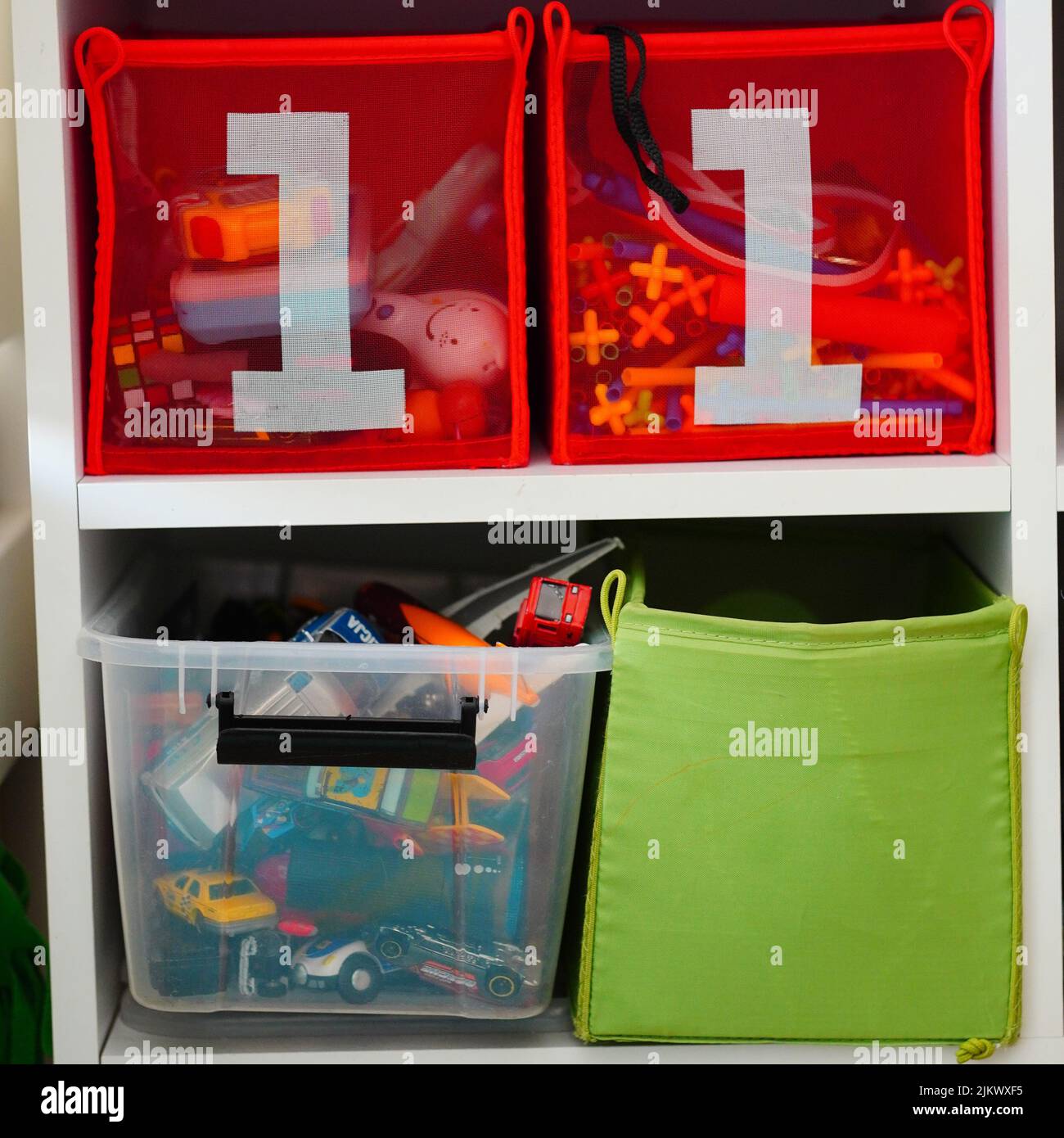 Different storage boxes filled with toys on shelves Stock Photo Alamy