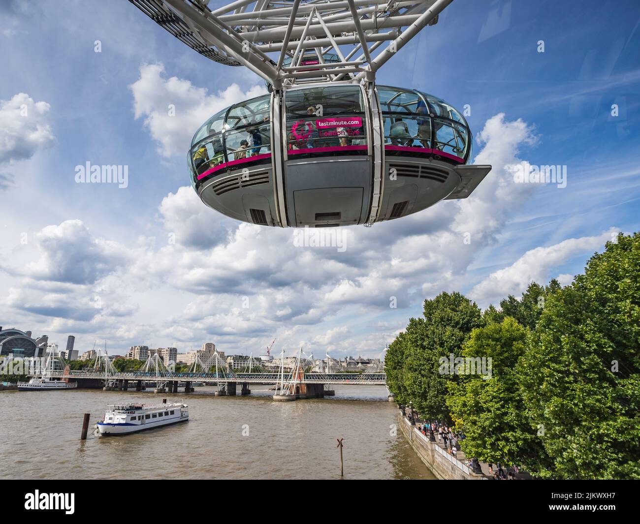 Looking under a capsule on the London Eye as it begins to rotate over London giving tourists a unique experience above the River Thames, seen in Augus Stock Photo
