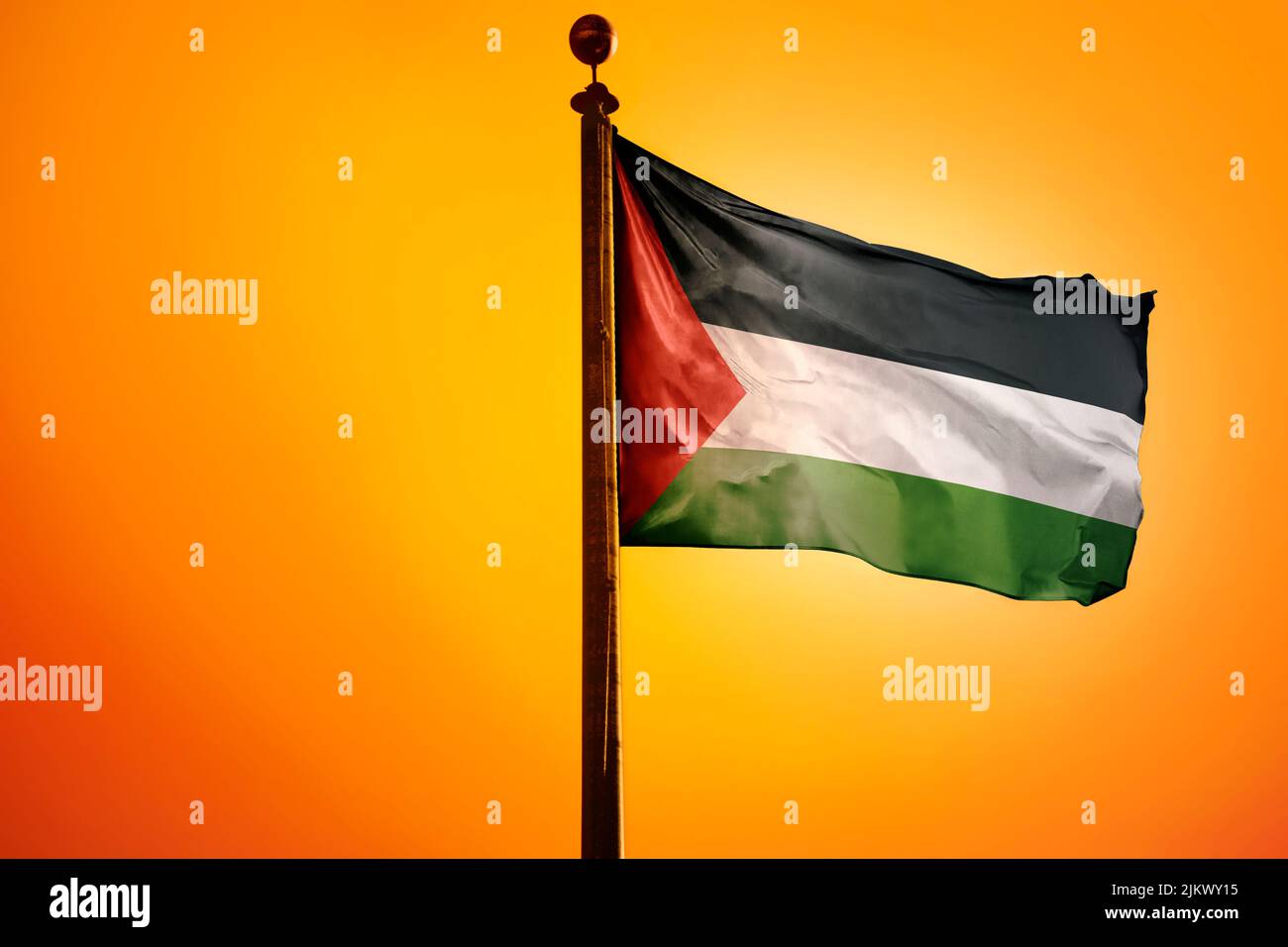 The national flag of Palestine on a flagpole isolated on an orange ...