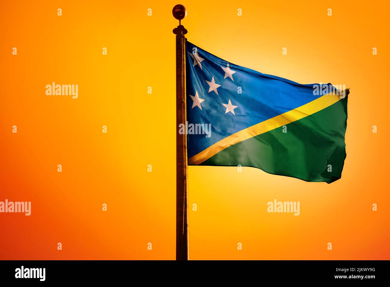 The national flag of the Solomon Islands on a flagpole isolated on an ...