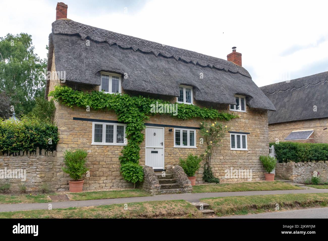 Ravenstone, Buckinghamshire, England, July 30, 2022:A traditional Thatched cottage in the village of Ravenstone North Buckinghamshire Stock Photo