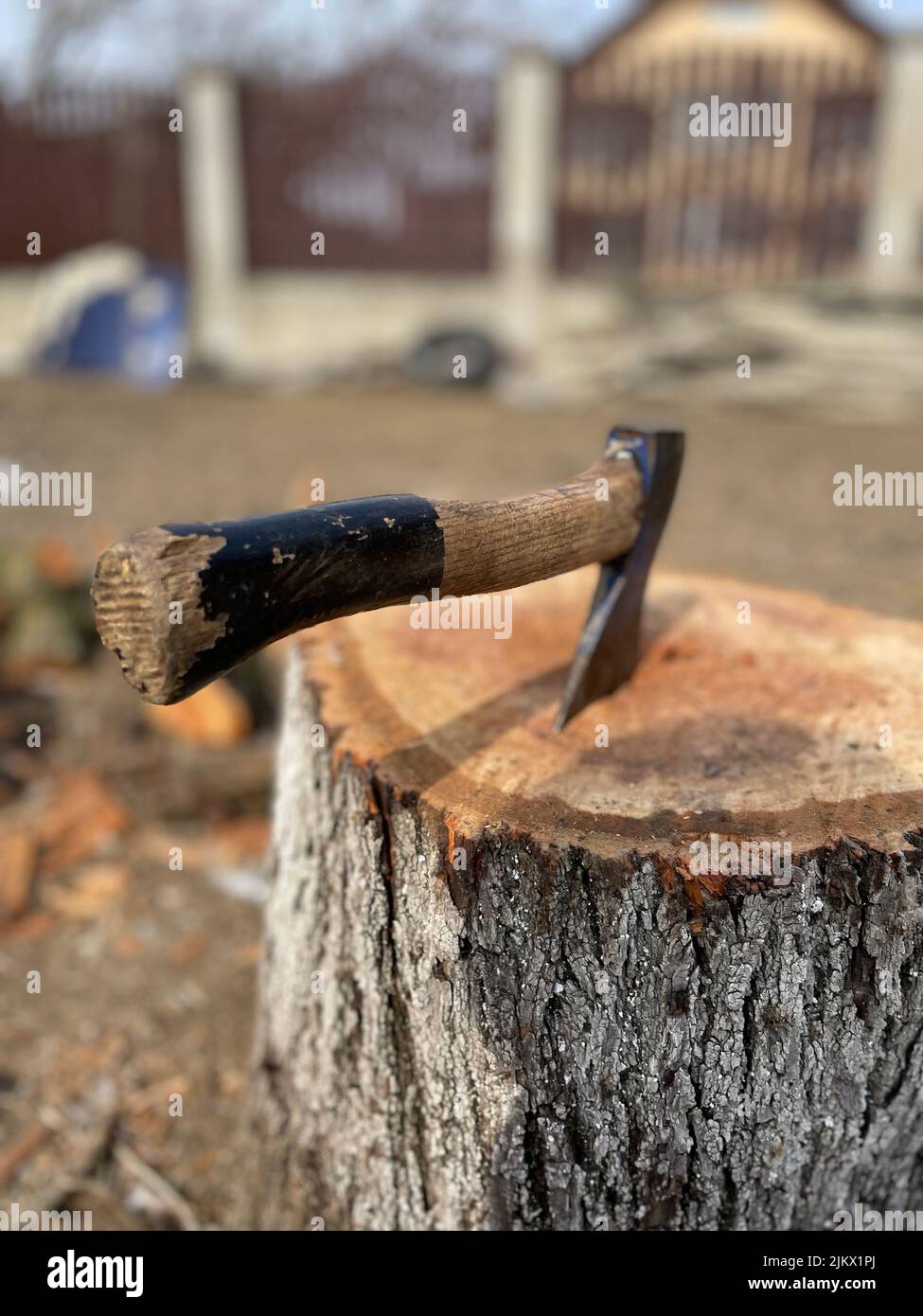 An old ax with a wooden handle stuck in a wooden log Stock Photo