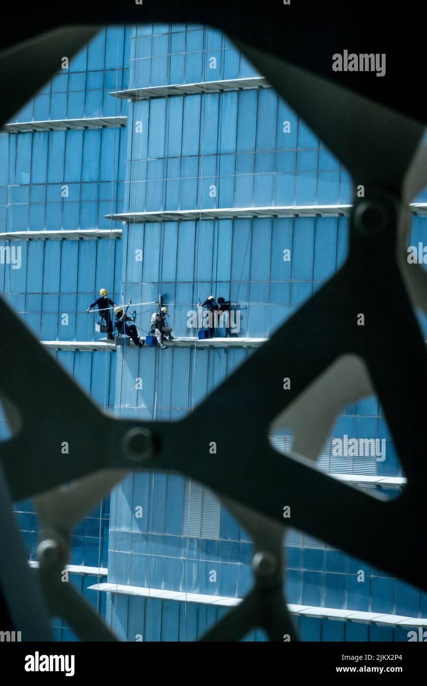 A vertical shot of men cleaning the windows of towers in Doha, Qatar