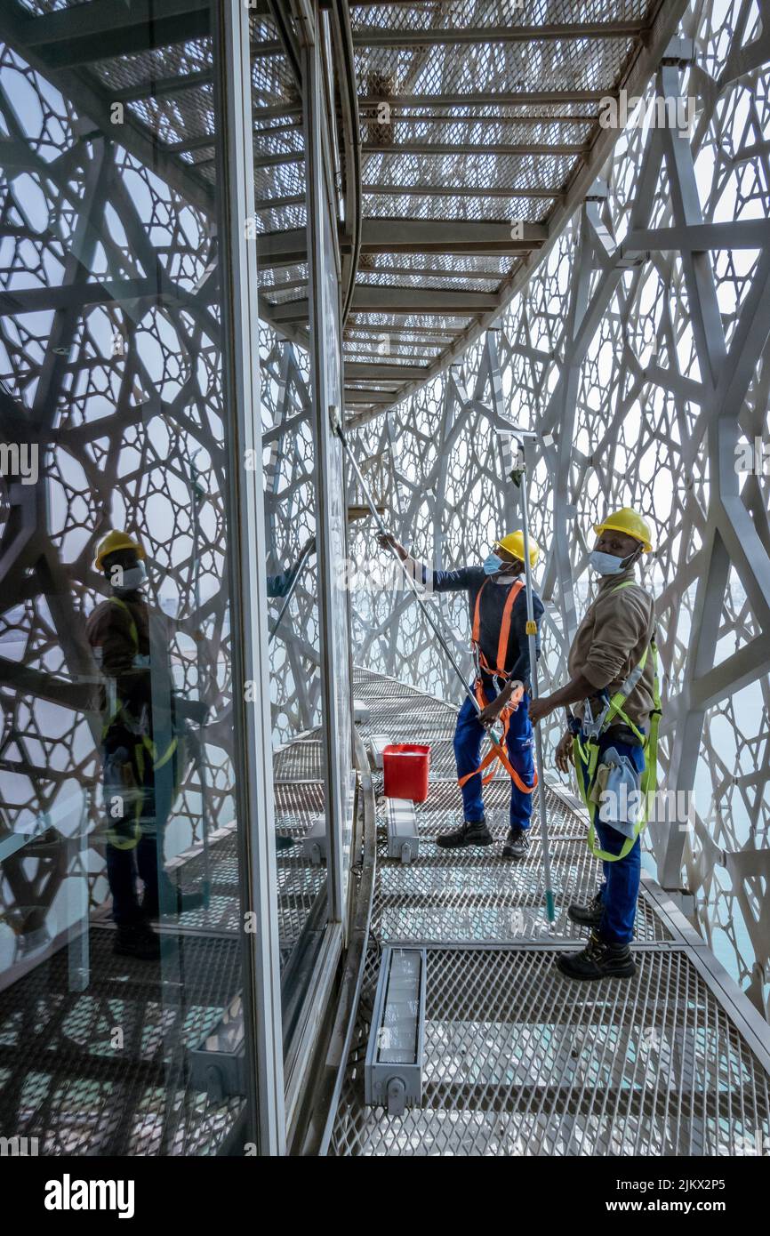 A vertical shot of men cleaning the windows of towers in Doha, Qatar
