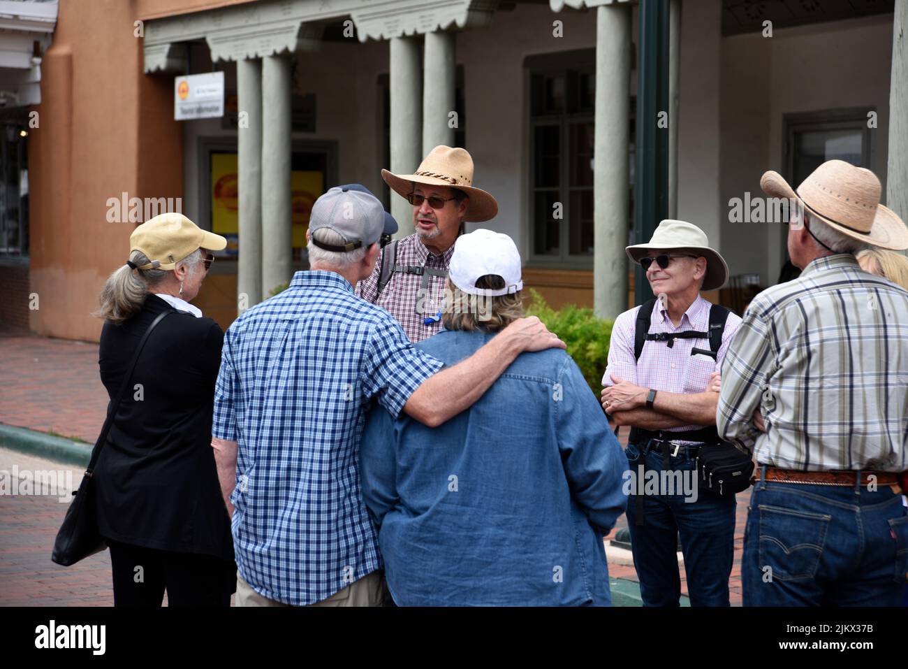 A tour guide leads a group of visitors around the historic district in Santa Fe, New Mexico. Stock Photo