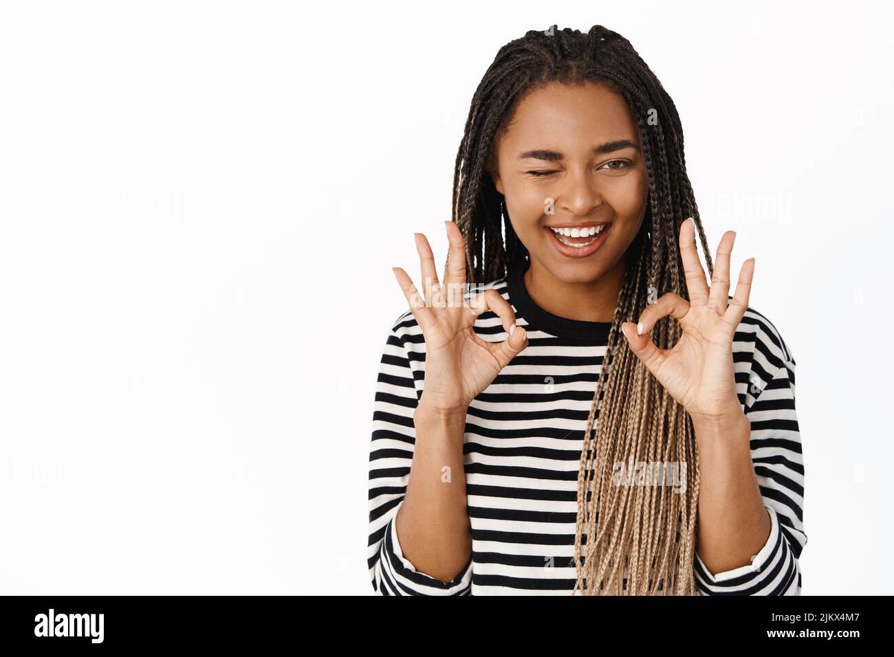 Okay, excellent. Smiling black girl winking, showing okay sign and ...