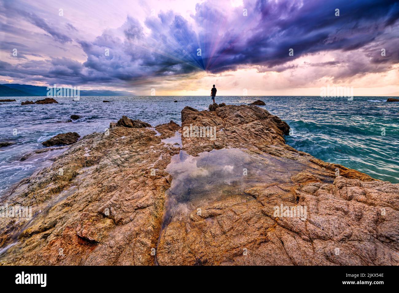 A Man Is Looking In Awe At Colored Light Beams Emanating From The Sky ...