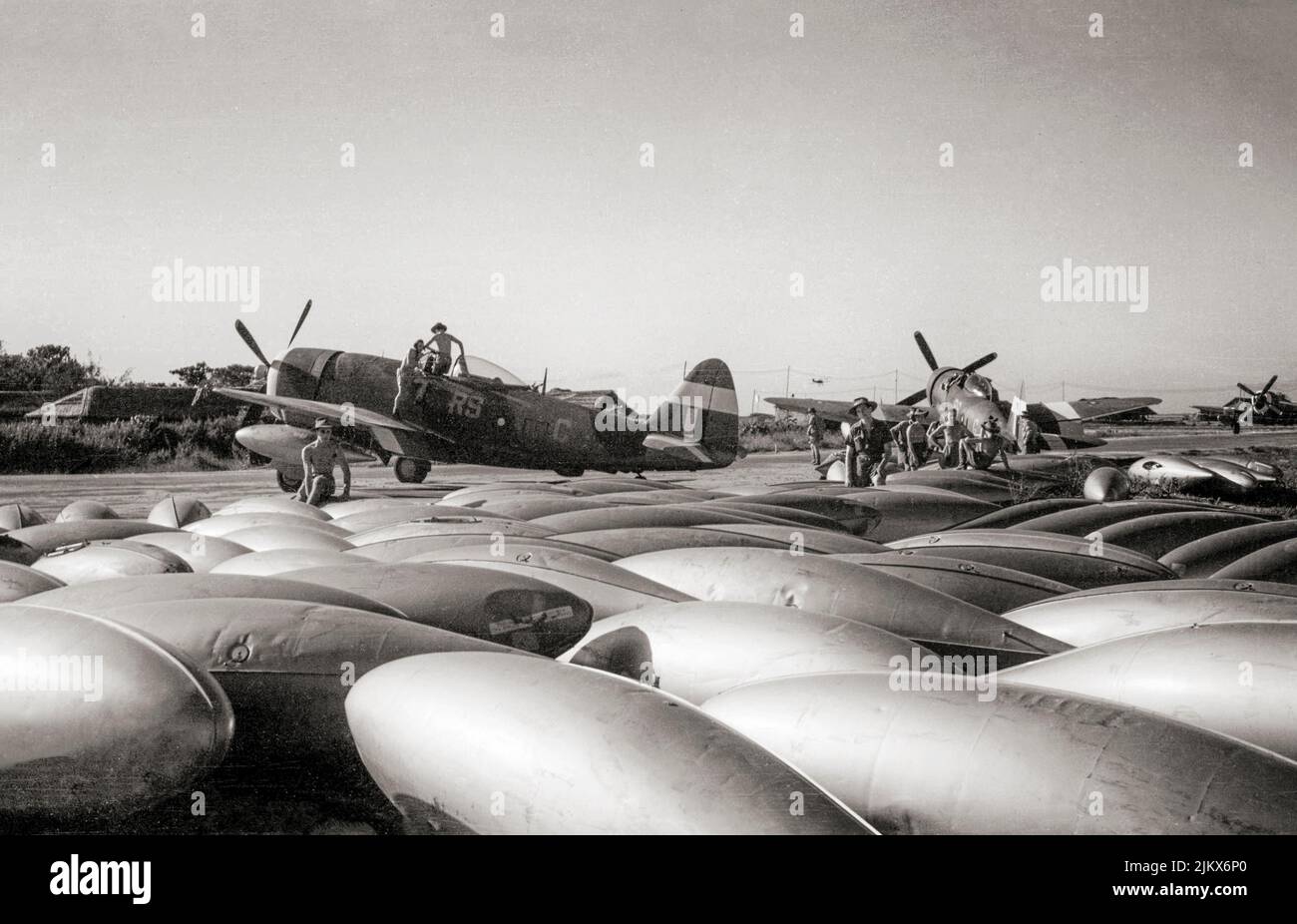 Long-range, 37-gallon drop-tanks next to a Republic Thunderbolt Mark IIs of No. 30 Squadron RAF, as they are readied for a sortie at Cox's Bazaar, India. The Thunderbolt was a World War II-era fighter aircraft produced by the American aerospace company Republic Aviation from 1941 through 1945. It could  a bomb load of 2,500 lb (1,100 kg) making it one of the heaviest fighters of the war. Stock Photo