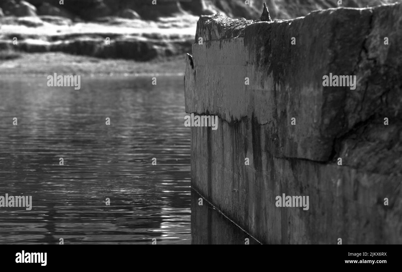 A grayscale shot of stone structure in the water Stock Photo