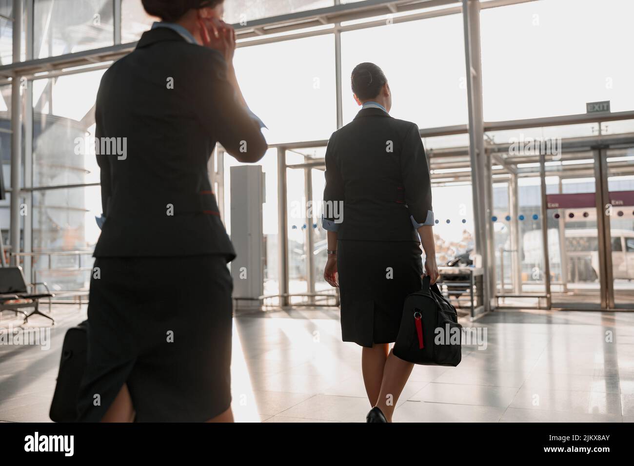 Two stewardesses walking to the airport terminal exit Stock Photo - Alamy