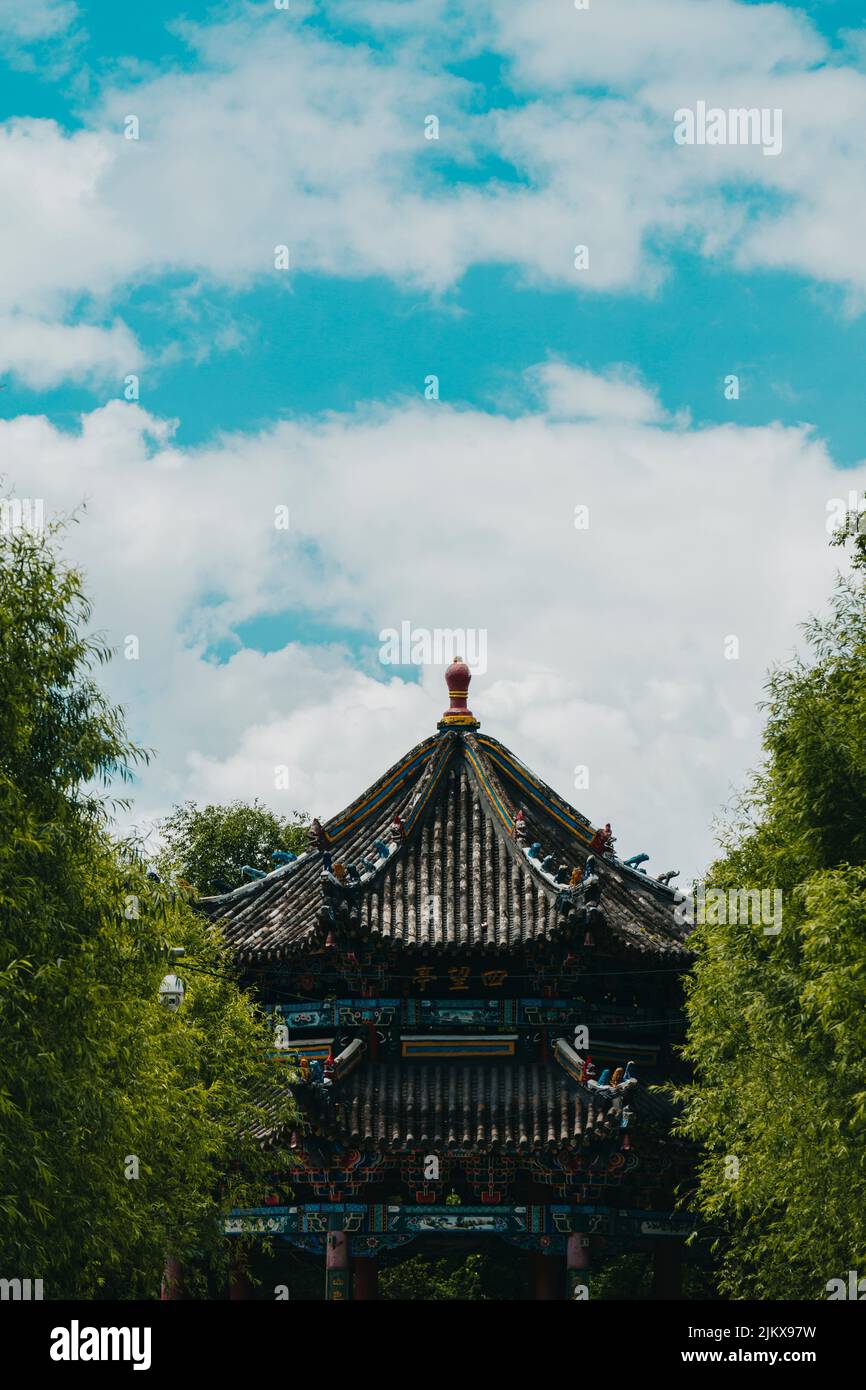 An ancient Asian temple from green trees Stock Photo