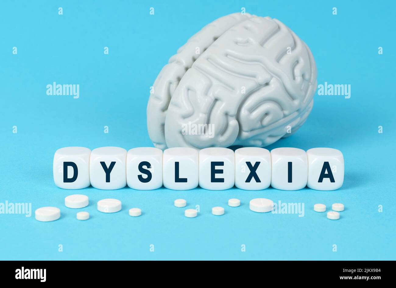Medicine and health. Cubes lie on the table among the pills and imitation of the brain. The text on the dice - DYSLEXIA Stock Photo