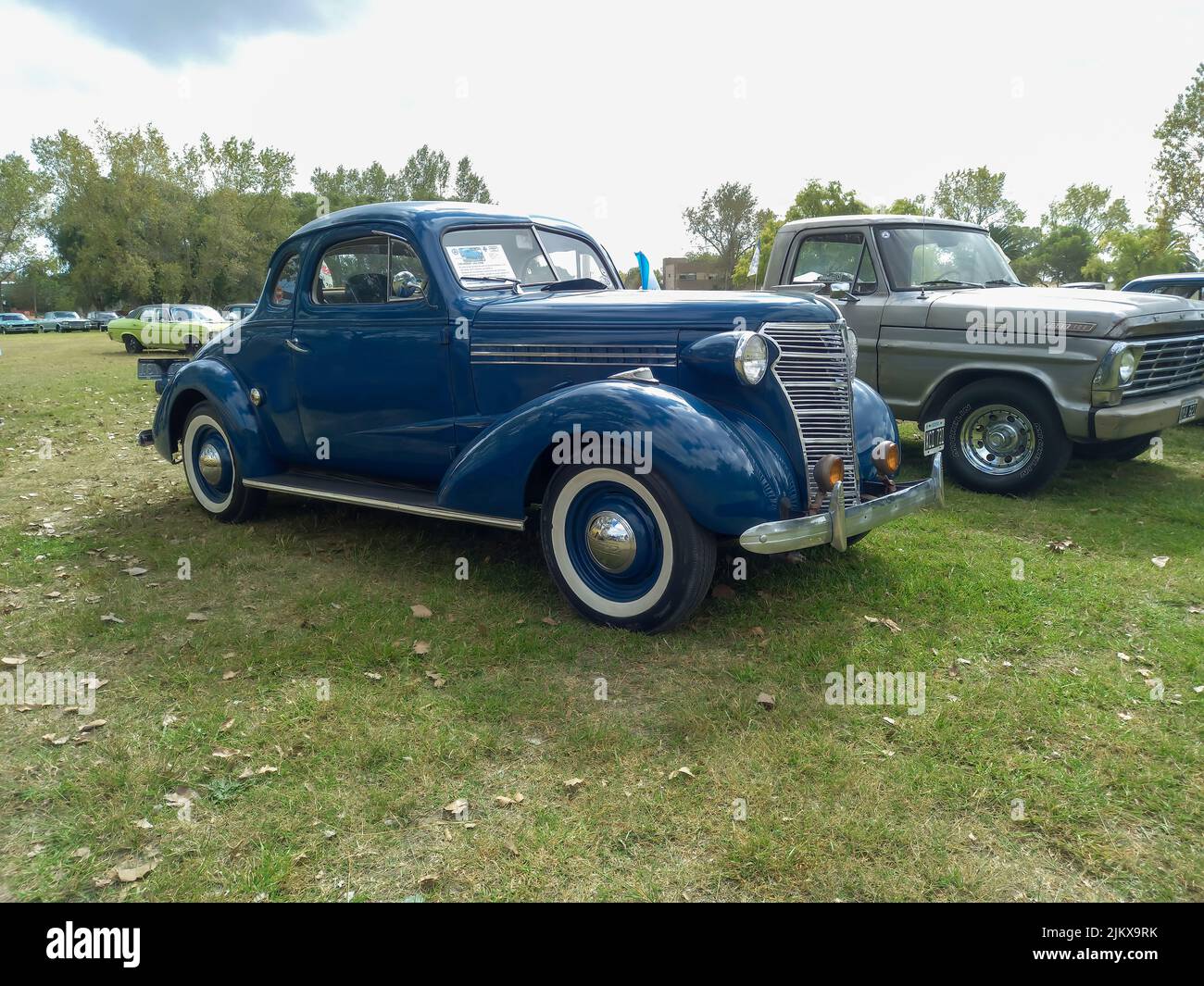 Chascomus, Argentina - Apr 9, 2022: Old blue Chevrolet Chevy Master business coupe 1938 by GM. Green nature grass and trees background. Classic car sh Stock Photo