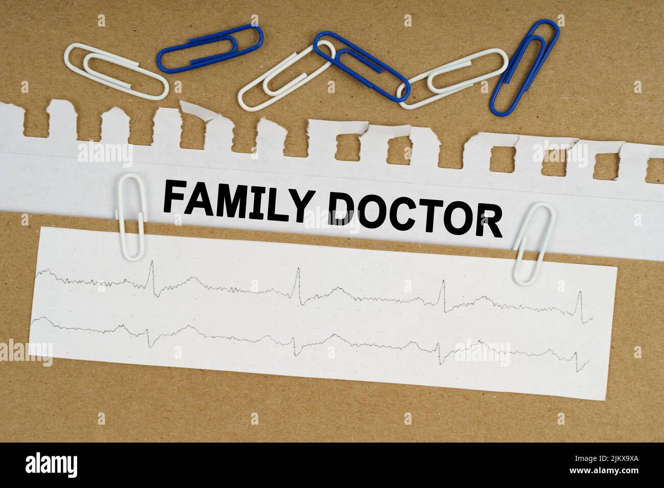 Medicine and health concept. On the table lies a cardiogram, paper clips and paper with the inscription - FAMILY DOCTOR Stock Photo