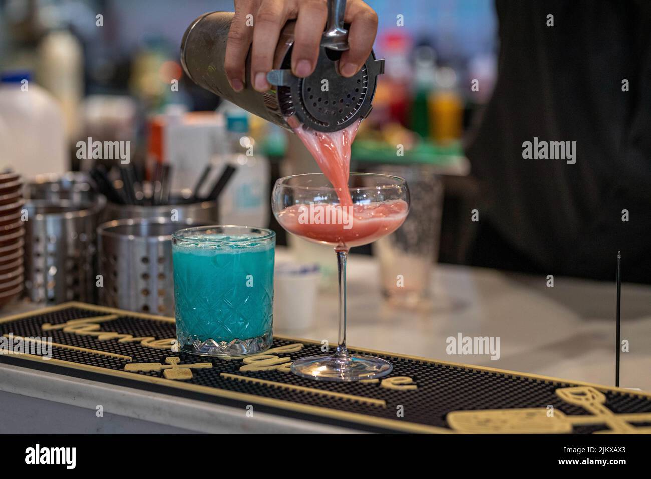 A closeup shot of a barman pouring a cocktail in a glass Stock Photo