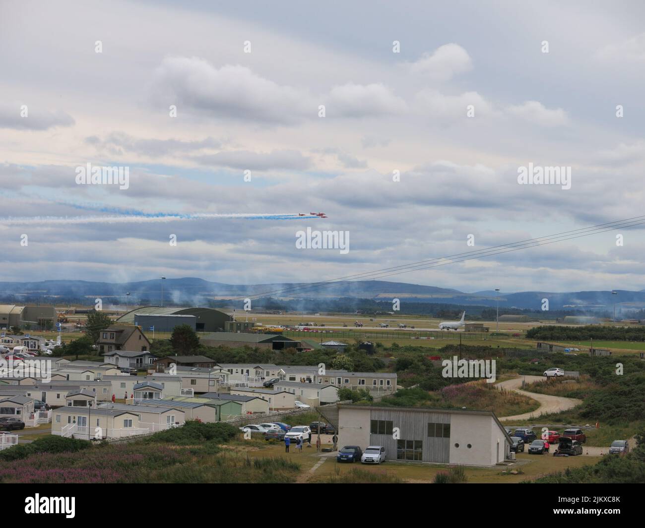 The Red Arrows fly over RAF Lossiemouth, with a view over the caravans at the Silver Sands Holiday Camp looking towards the base. Stock Photo