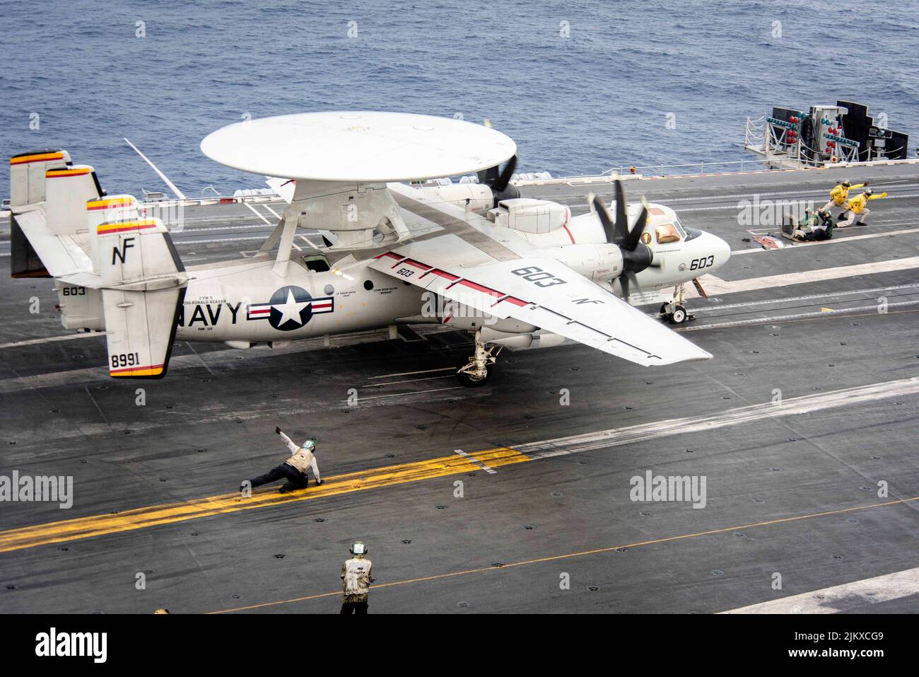 Philippine Sea. 11th July, 2022. An E-2D Hawkeye attached to the 'Tigertails'' of Airborne Early Warning Squadron (VAW) 125 prepares to take off from the flight deck of the U.S. Navy's only forward-deployed aircraft carrier USS Ronald Reagan (CVN 76). E-2D Hawkeyes perform tactical airborne early warning missions to provide valuable information to Carrier Strike Group 5 as it plans and executes operations. Ronald Reagan, the flagship of Carrier Strike Group 5, provides a combat-ready force that protects and defends the United States, and supports alliances, partnerships and collective mar Stock Photo