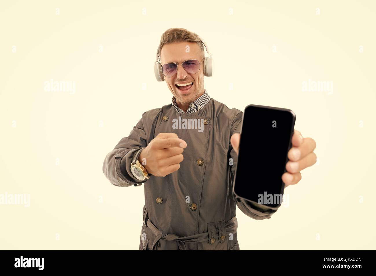 Smartphone for music lovers. Happy guy hold smartphone pointing finger. Listening to mobile music Stock Photo