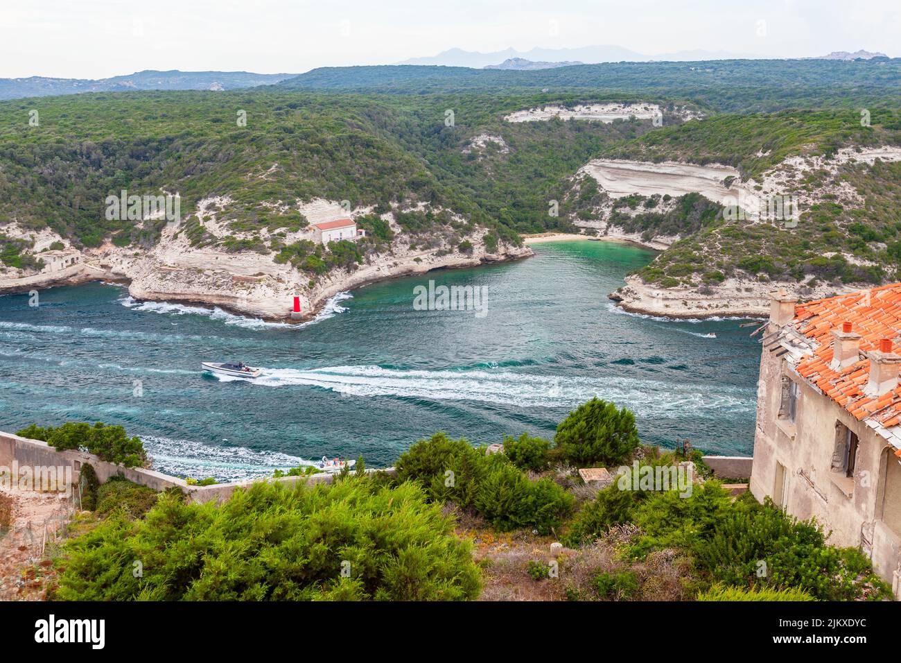Bonifacio, Corsica. Coastal view with motor boats sailing the inner harbor on a summer day Stock Photo