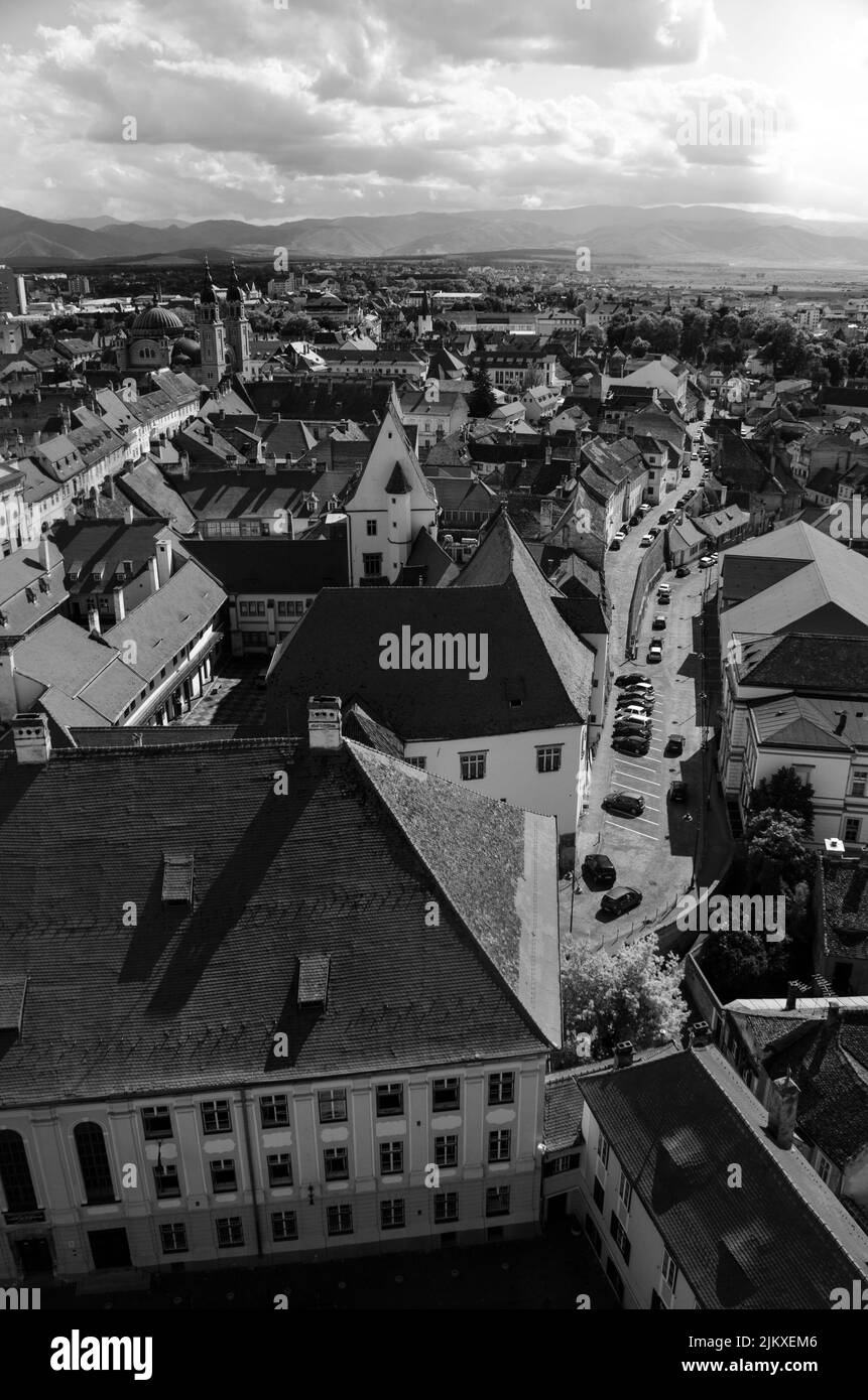 A vertical grayscale aerial drone shot of the rooftops of houses in Sibiu, Romania Stock Photo
