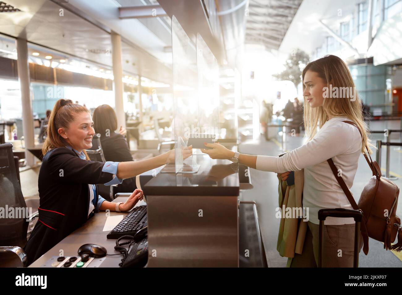 Female traveler giving her passport to an airport staff member Stock Photo
