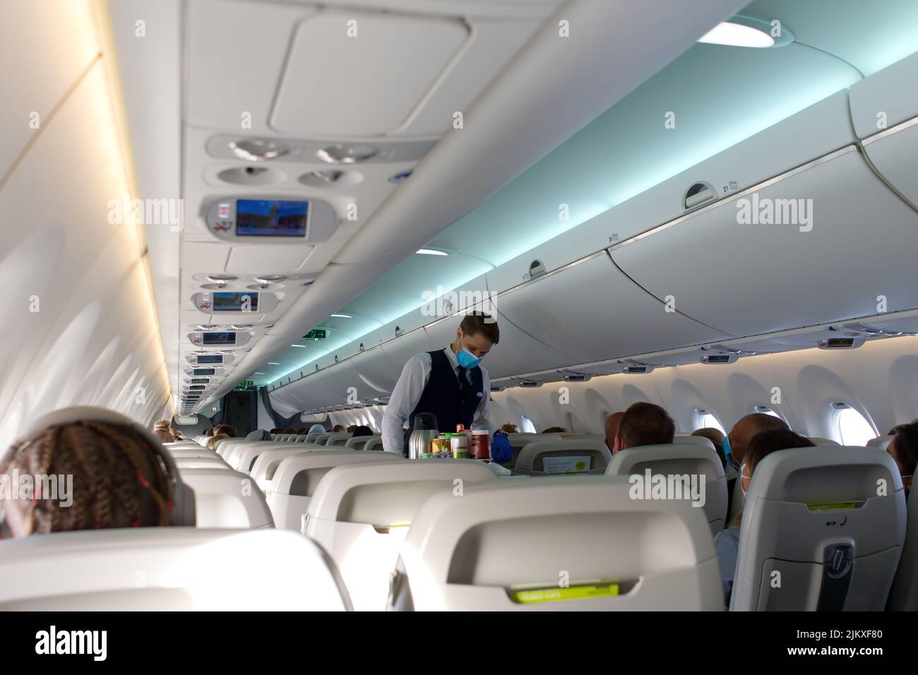 Passengers traveling by plane, inside of an airplane. steward serving food and drinks Stock Photo