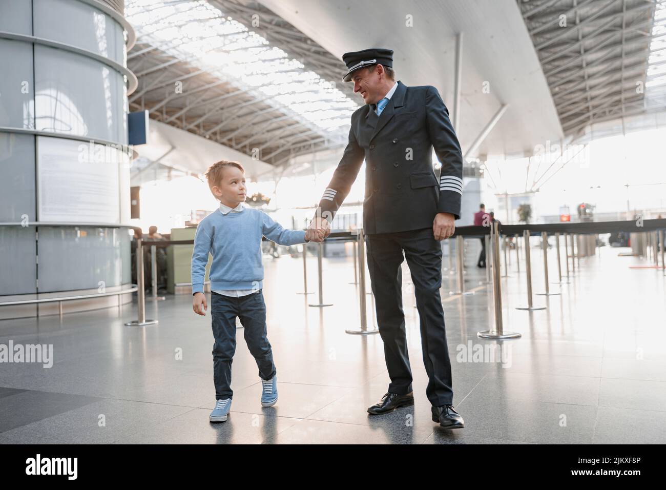 Little boy and pilot holding hands at the airport Stock Photo