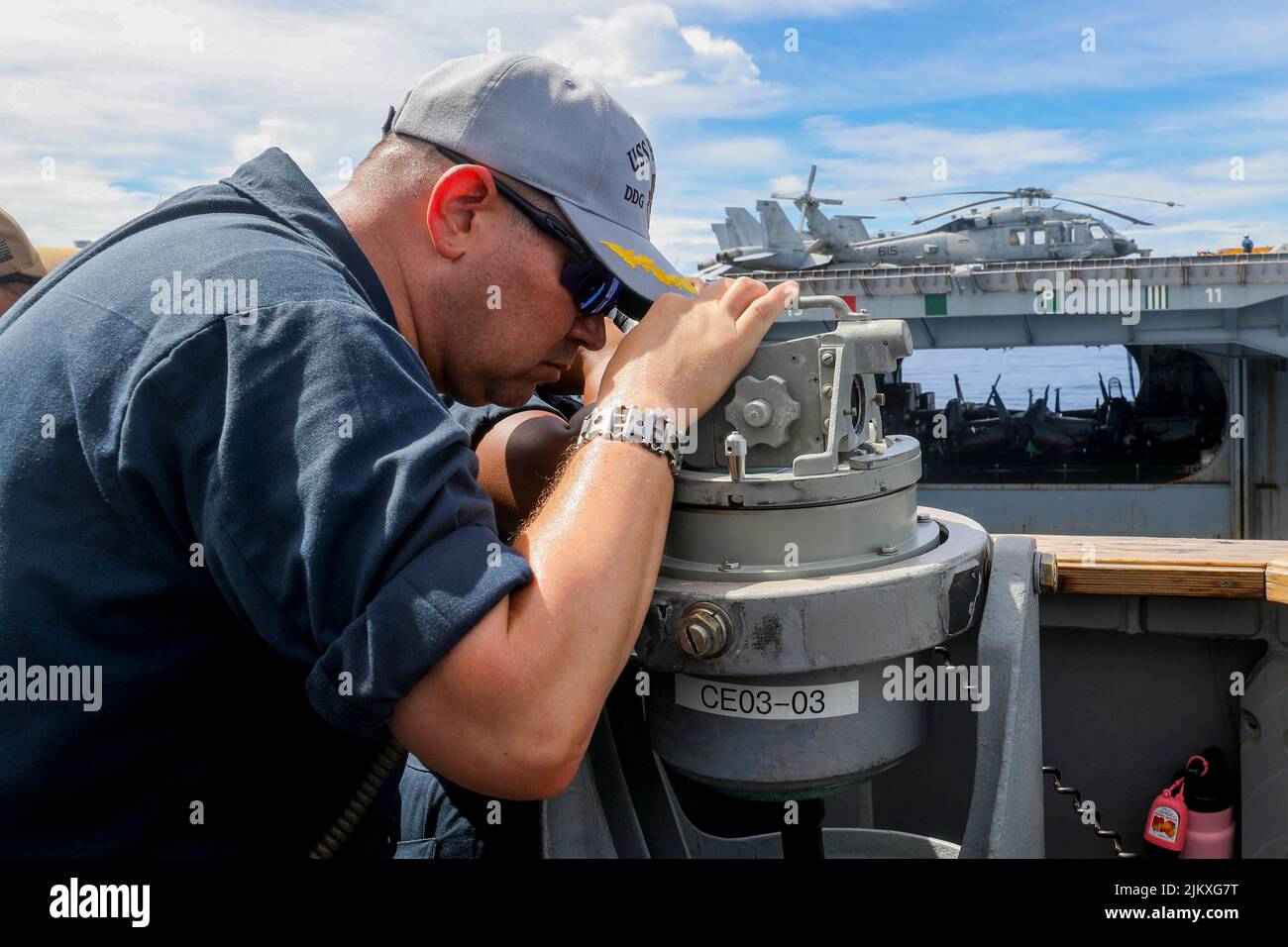Philippine Sea. 26th July, 2022. Executive Officer Cmdr. Cameron Dennis, from San Antonio, looks through a telescopic alidade on the bridge wing of Arleigh Burke-class guided-missile destroyer USS Higgins (DDG 76) during a replenishment-at-sea with the U.S. Navy's only forward deployed aircraft carrier USS Ronald Reagan (CVN 76). Higgins is assigned to Task Force 71/Destroyer Squadron (DESRON) 15, the Navy's largest forward-deployed DESRON and the U.S. 7th fleet's principal surface force. Credit: U.S. Navy/ZUMA Press Wire Service/ZUMAPRESS.com/Alamy Live News Stock Photo