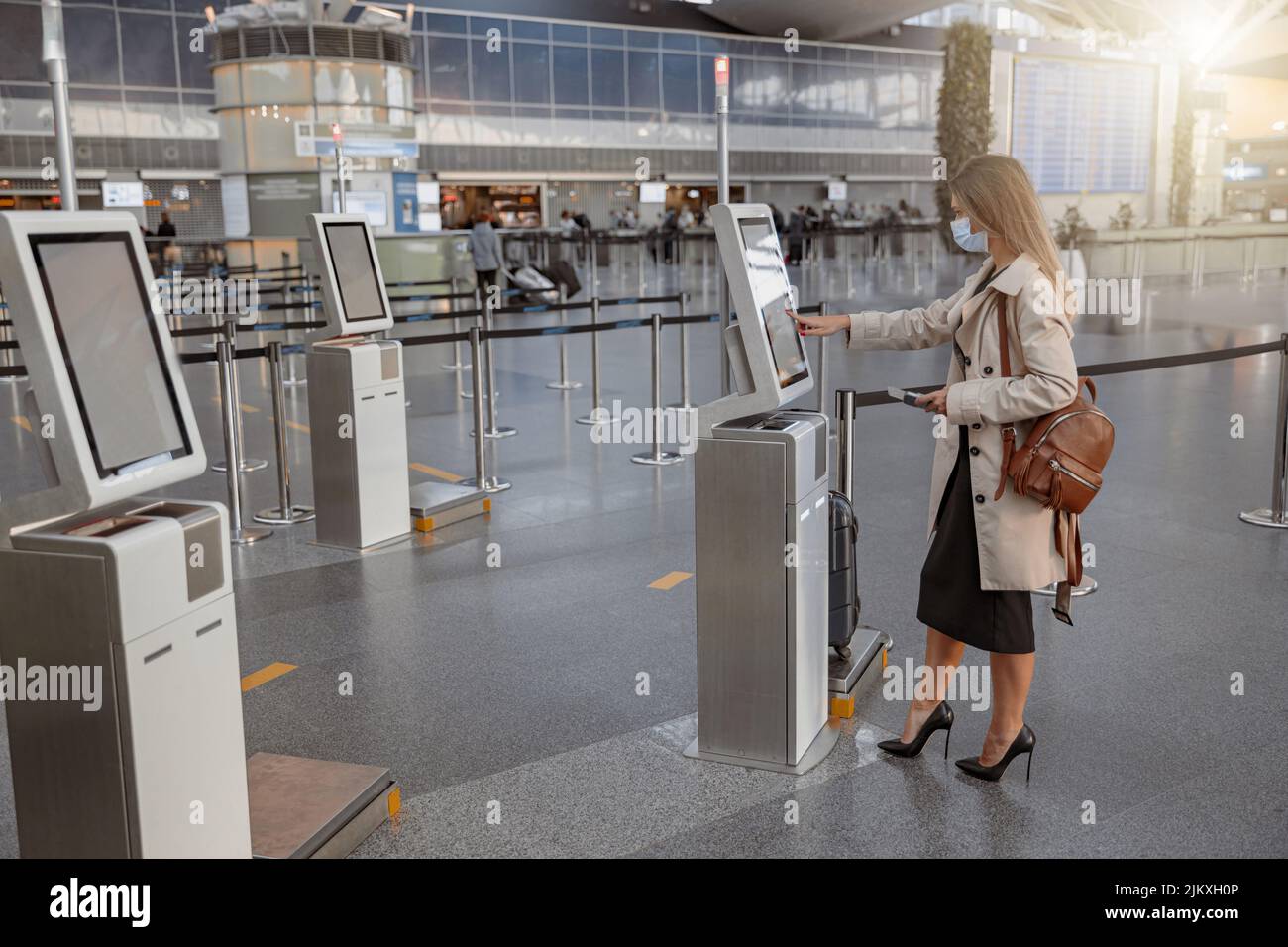 Pretty lady touching interactive screen to check in online in terminal Stock Photo